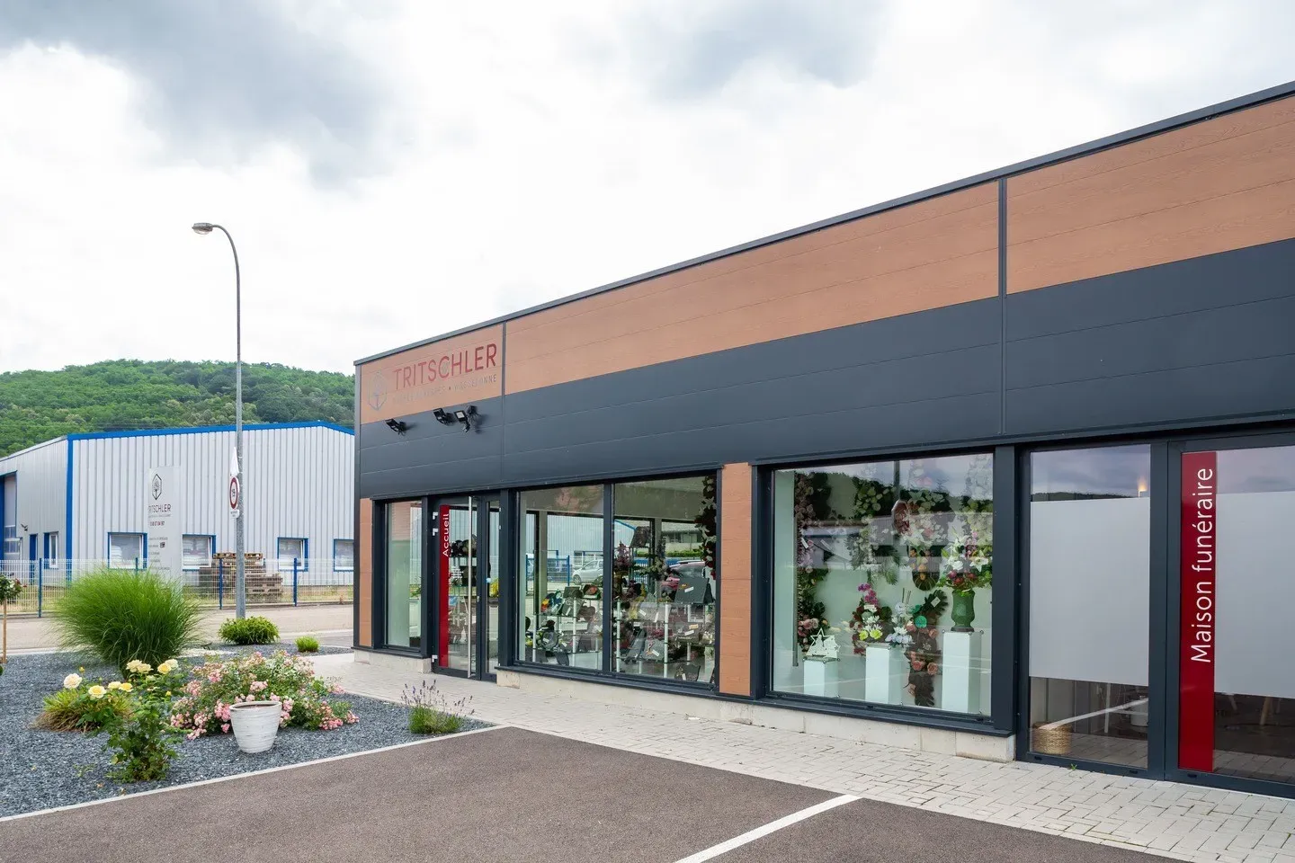 Façade moderne de la maison funéraire Tritschler avec vitrines d'exposition.