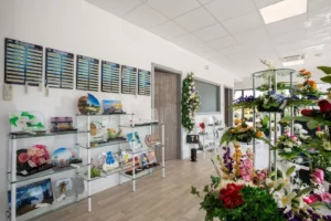 Magasin d'articles funéraires proposant des fleurs et des plaques en verre.